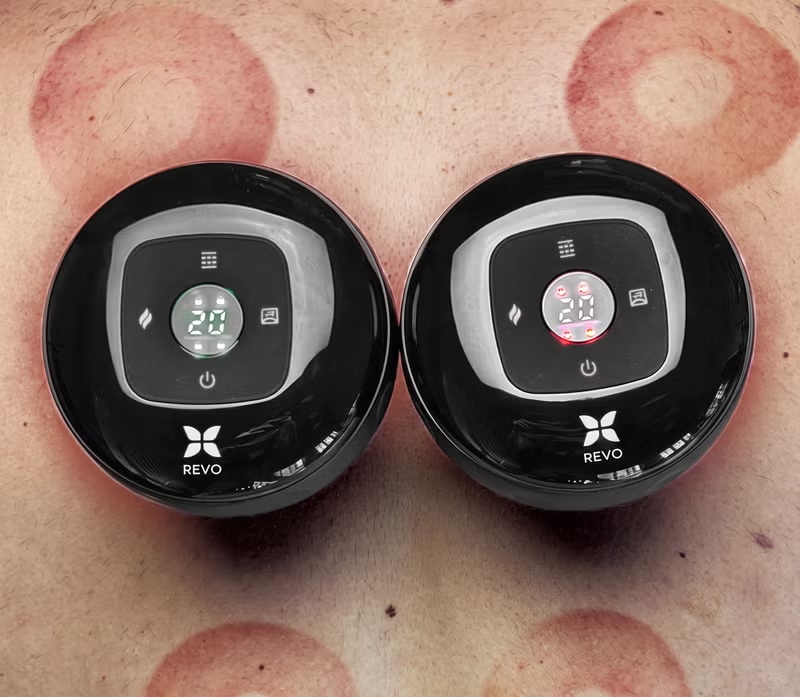 Revo Smart Cup held in a hand with the device illuminated